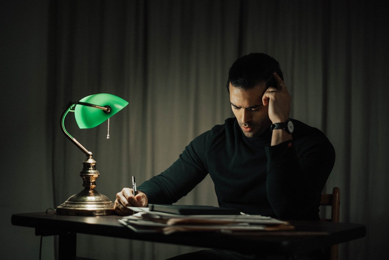 Image décorative - Homme assis sur une table analysant un document